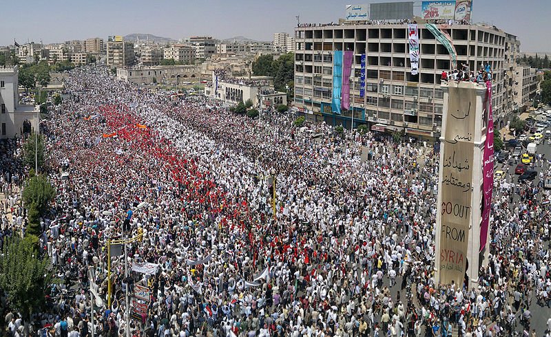 Στιγμιότυπο από την τεράστια διαδήλωση που έλαβε χώρα στην πόλη Χαμά στις 22 Ιούλη, λίγες μέρες πριν αρχίσει ο βομβαρδισμός της...